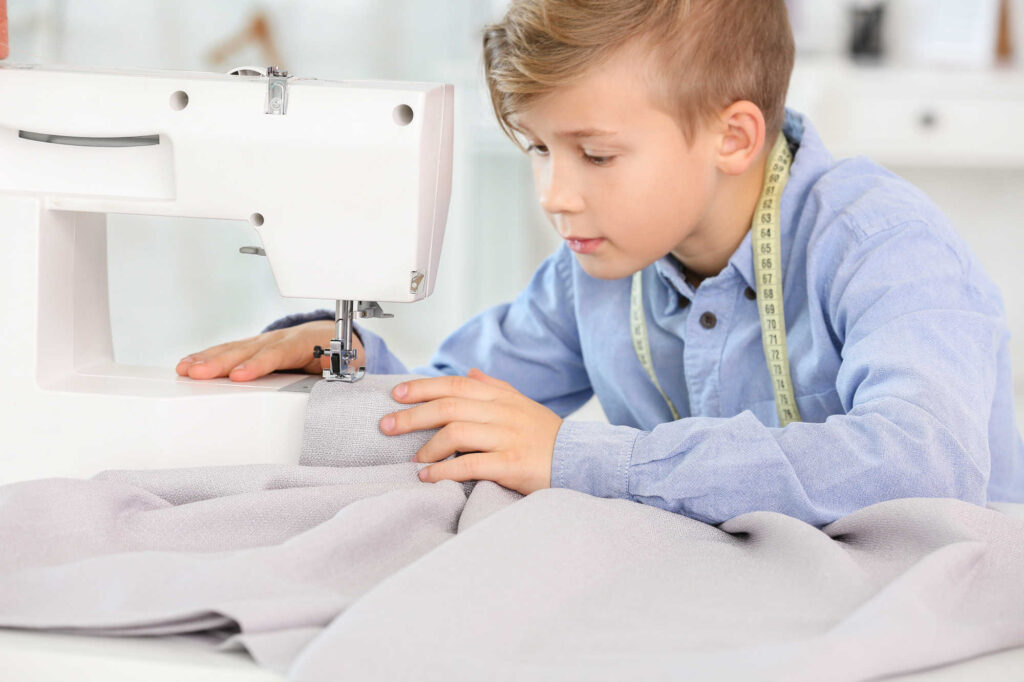 Picture of a white boy using a sewing machine.